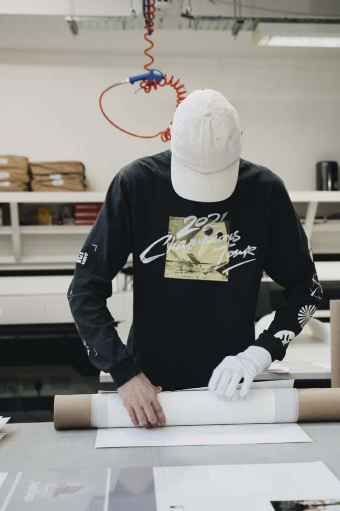 Person carefully rolling an art print into a tube representing branded, white-label packaging and fulfilment for artists’ collectors.