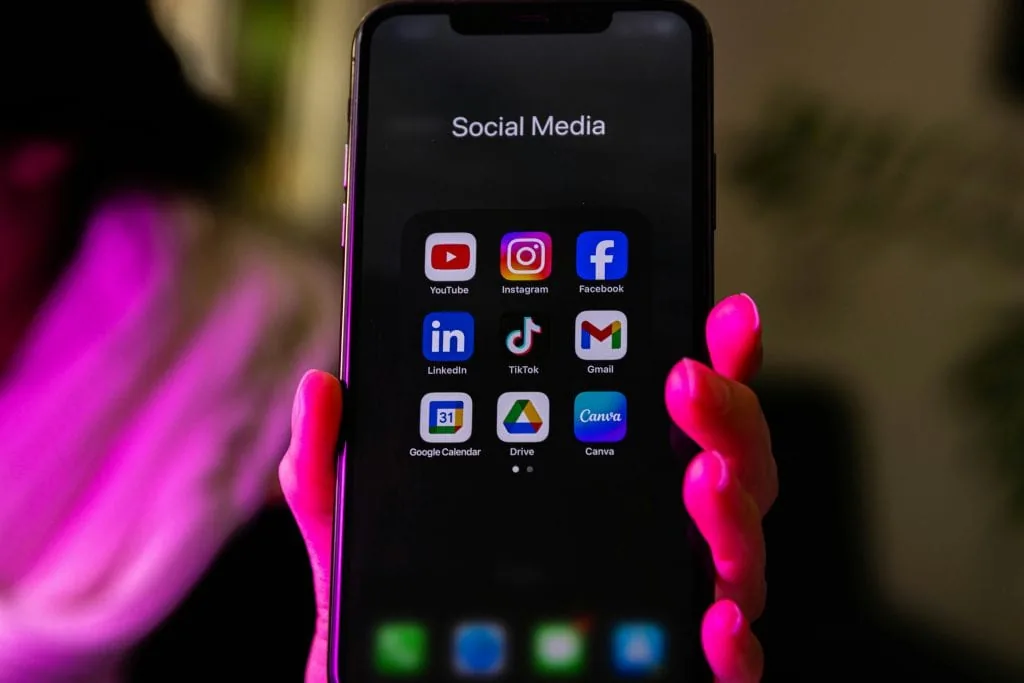 Phone screen showing social media apps illustrating how artists use social platforms to promote and price their art.